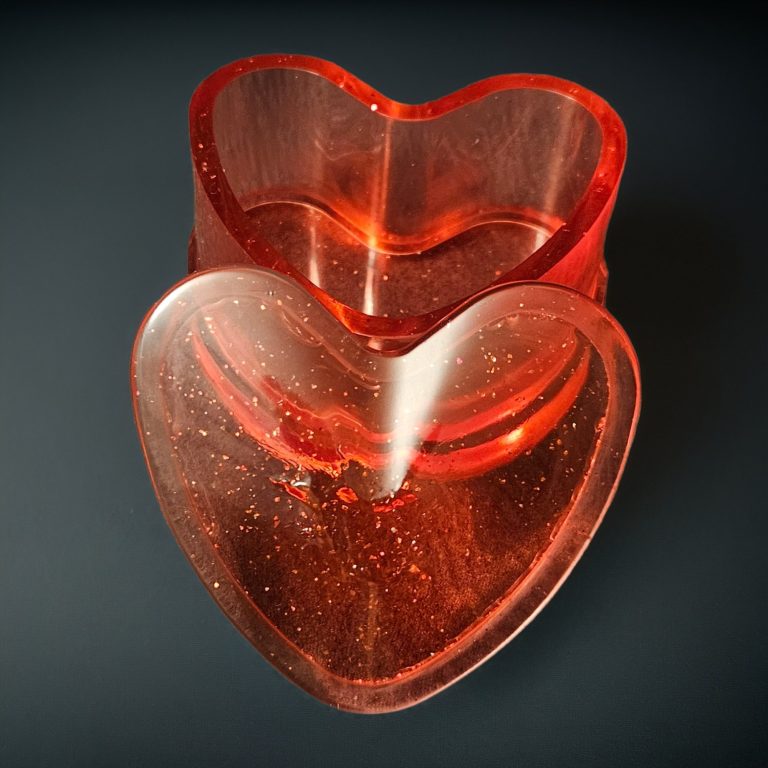 Rotes herzförmiges Harzkästchen mit Deckel – transparent mit Glitzereffekt, aus Epoxidharz.