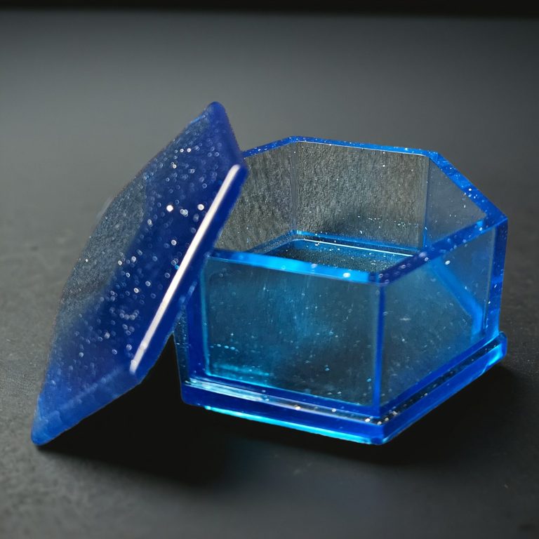 Blaue sechseckige Dosen mit Deckel aus glitzerndem, transparentem Harz.