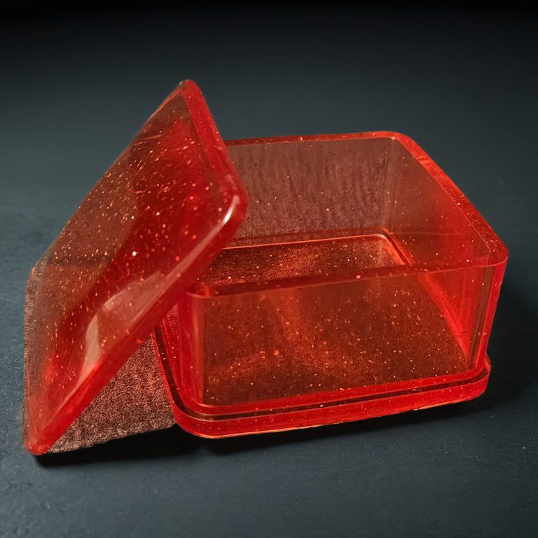 Rote quadratische Dose mit Deckel aus glitzerndem, transparentem Harz.