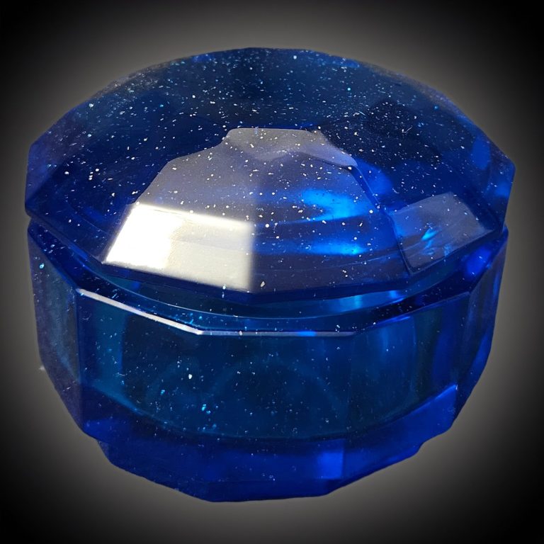 Blaue handgefertigte, glitzernde Kristalldose aus Harz mit facettierter Oberfläche und rundem Deckel.