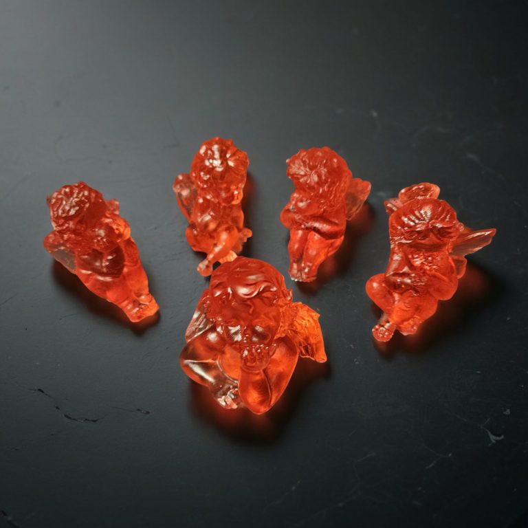 Fünf handgefertigte rote Engelfiguren aus Harz, glänzend-transparent gegossen, mit verschiedenen Posen.