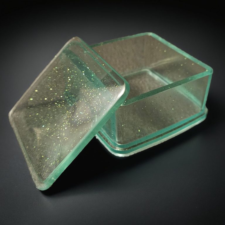 Grüne quadratische Dose mit Deckel aus glitzerndem, transparentem Harz.
