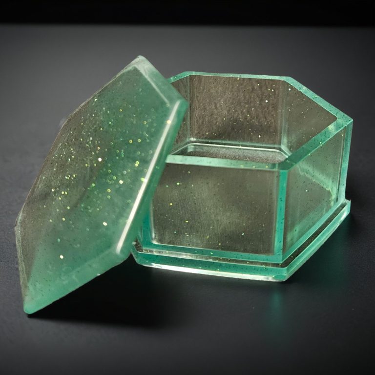 Grüne sechseckige Dosen mit Deckel aus glitzerndem, transparentem Harz.