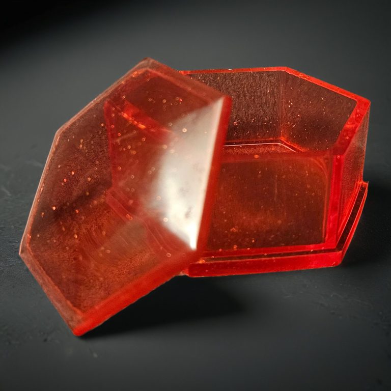 Rote sechseckige Dosen mit Deckel aus glitzerndem, transparentem Harz.